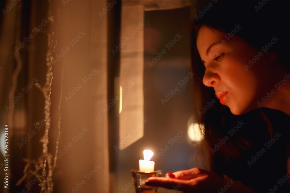 Christmas evening girl / beautiful young adult model, dreams and makes wishes at the candles in the New Year's Eve Christmas evening girl / beautiful young adult model, dreams and makes wishes at the candles in the New Year's Eve