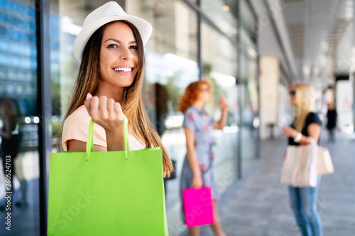 Young happy attractive girls with shopping bags in the city.