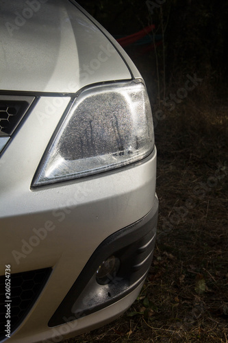 Shiny car with silver paint. Water drops on the hood.