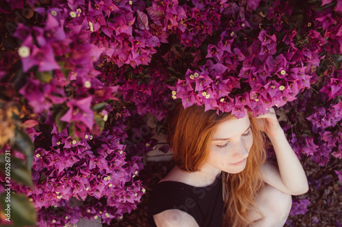 Fotografiet Portrait of girl with closed eyesamong purple bougainvillaea