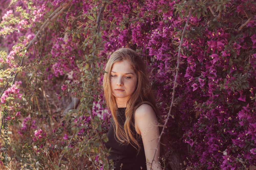 Portrait of girl among purple bougainvillaea