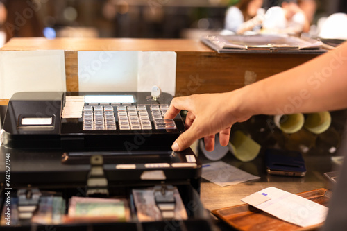 Schilderij op canvas Shot in low light hand pressing electronic cash register in a shop