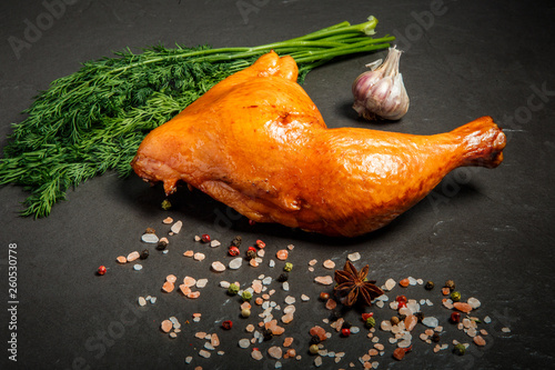 Фотография one smoked chicken thigh with fresh dill, garlic and spices