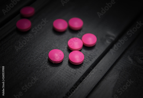 Medical pills on the dark wooden background