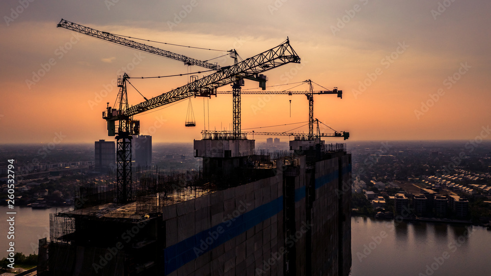 Construction site silhouette background, Hoisting cranes and new multi-storey buildings, Aerial view Industrial background.
