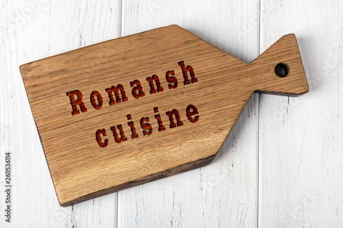 Wooden cutting board with inscription. Concept of romansh cuisine photo