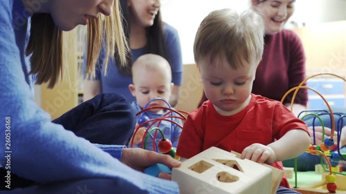 Group Of Mothers And Toddlers Playing With Toys At Playgroup