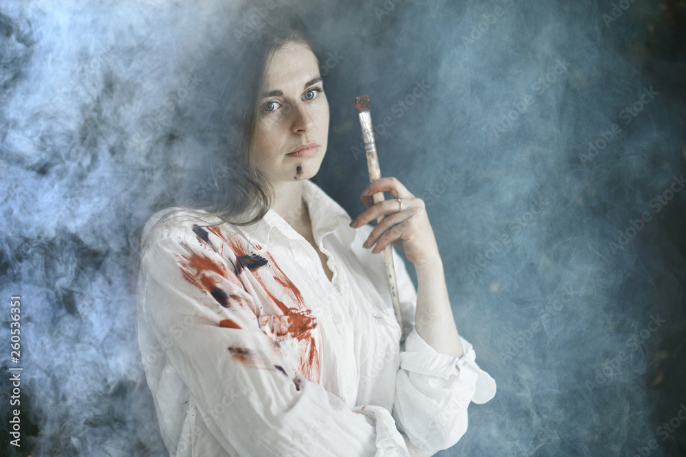 Fototapeta premium Young artist girl at work in the workshop brush paints canvas inspiration