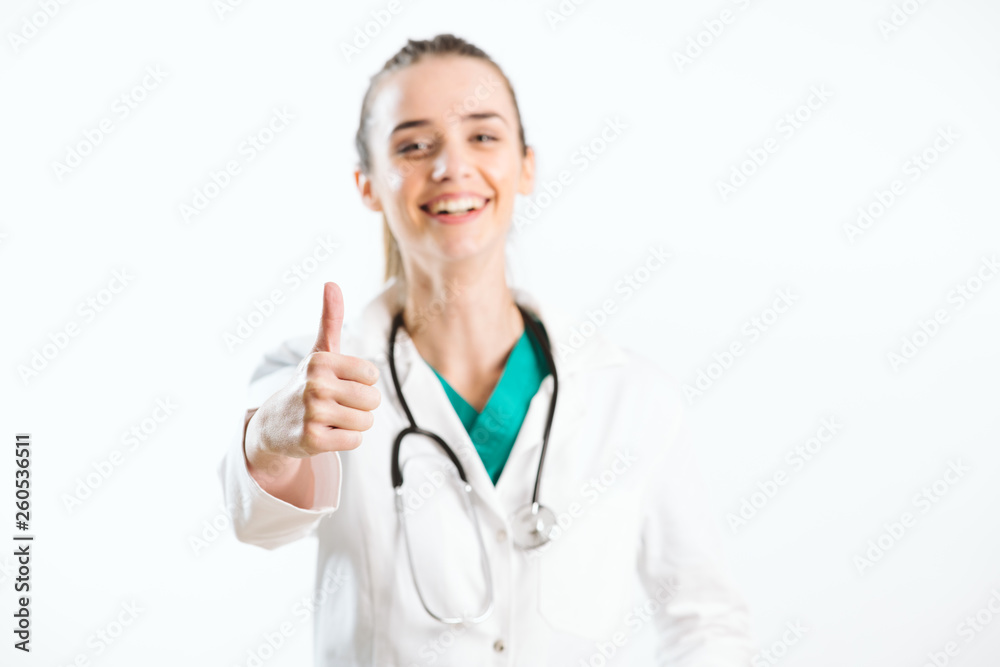 Young smiley nurse puts thumb up, wears scrub uniform and stethoscope. Young smiley nurse puts thumb up, wears scrub uniform and stethoscope.