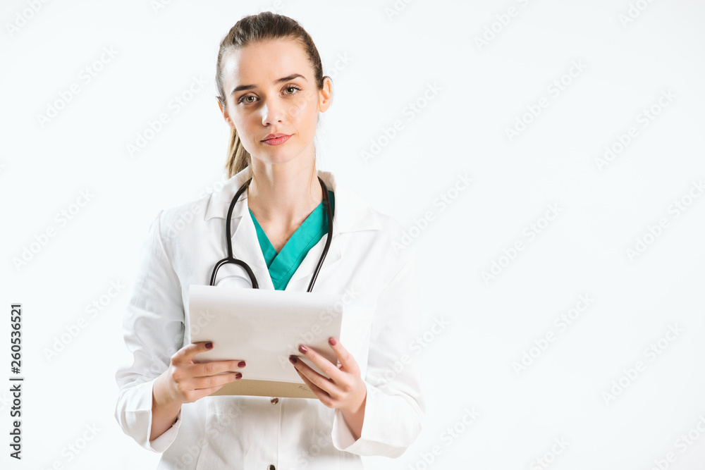 Young nurse with stethoscope and papers in her scrub uniform.