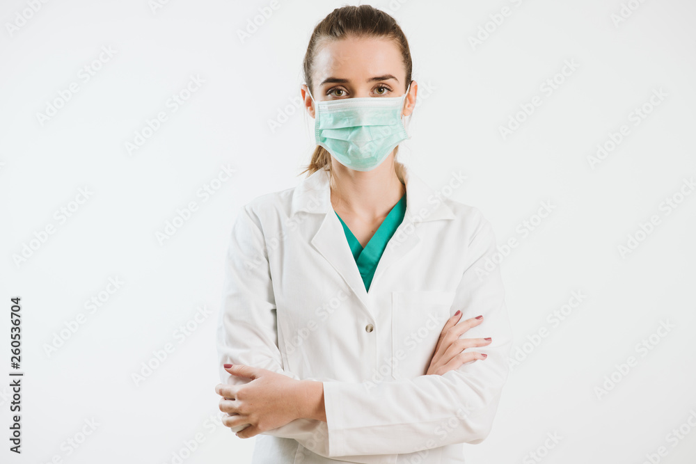 Young nurse in a scrub uniform wearing a face mask. Young nurse in a scrub uniform wearing a face mask.