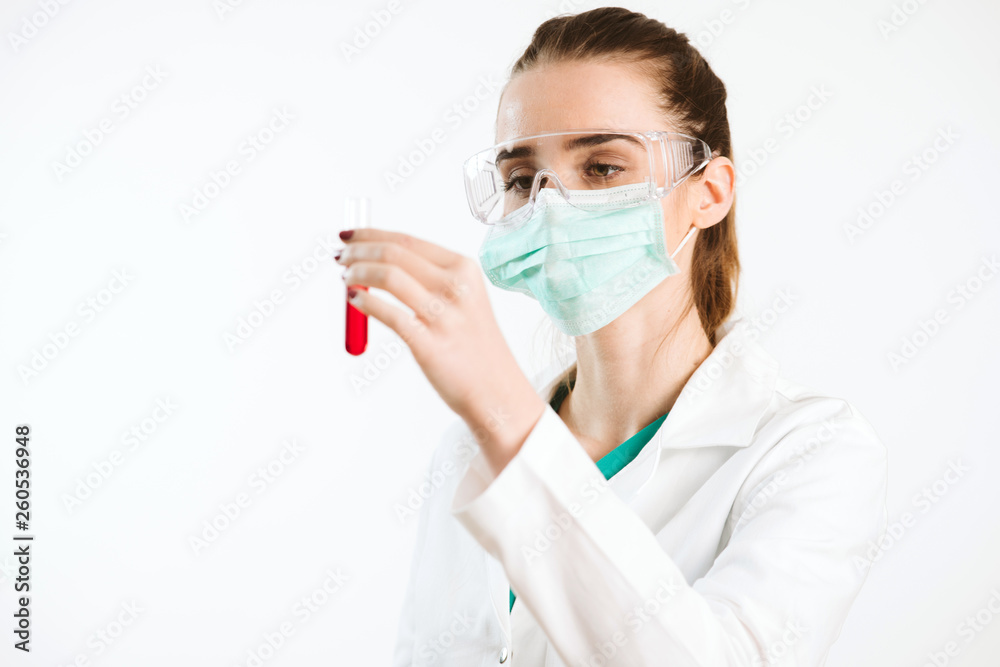 Young nurse holding a test tube, testing liquid.
