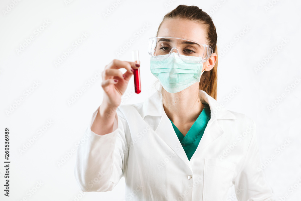 Young nurse holding a test tube, testing liquid. Young nurse holding a test tube, testing liquid.