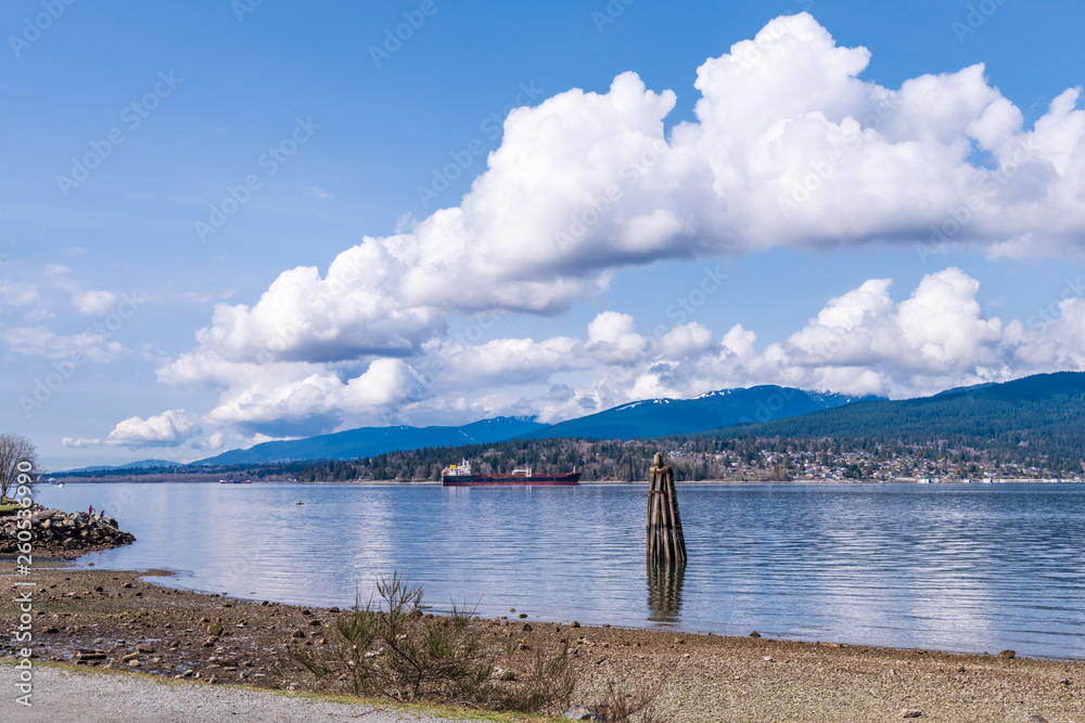Fantastic view over ocean, snow mountain and rocks at Burrard inlet in Vancouver, Canada.