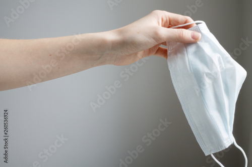 hand holding a medical mask on a light background