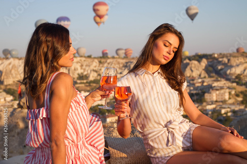 Friends toasting rose wine glass and having fun outdoors