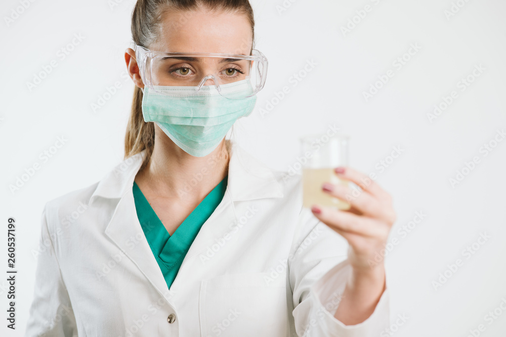 Young nurse holding a test tube, testing liquid. Young nurse holding a test tube, testing liquid.