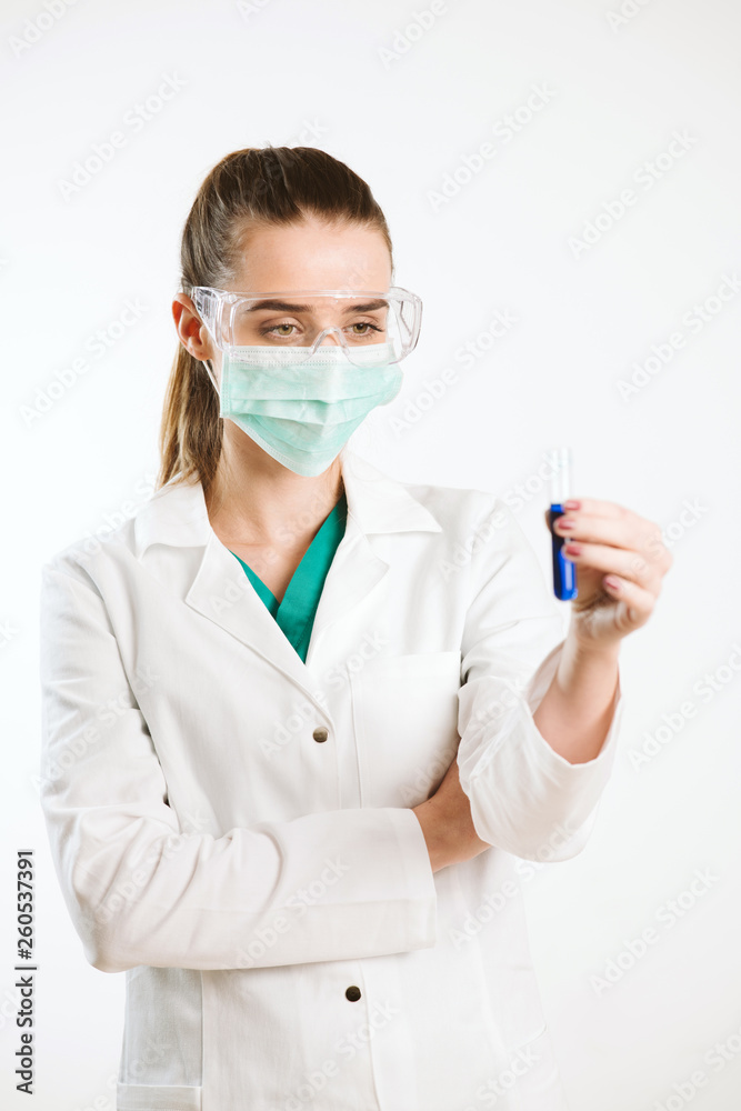 Young nurse holding a test tube, testing liquid. Young nurse holding a test tube, testing liquid.