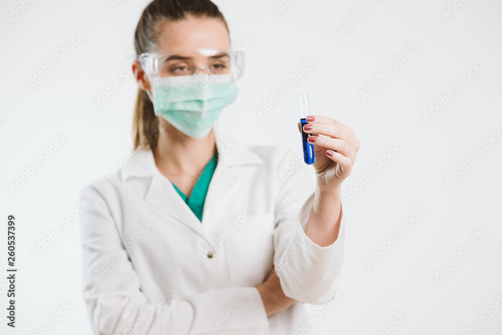 Young nurse holding a test tube, testin liquid. Young nurse holding a test tube, testin liquid.