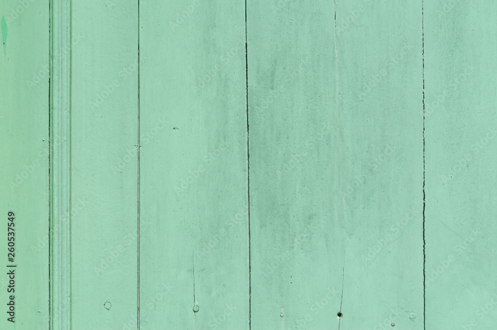 Faded green or blue wooden background with some cracked spots and vertical pattern on it Faded green or blue wooden background with some cracked spots and vertical pattern on it