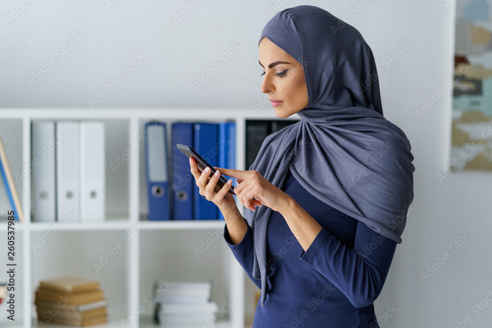 Arabic woman dials a number Arabic woman dials a number
