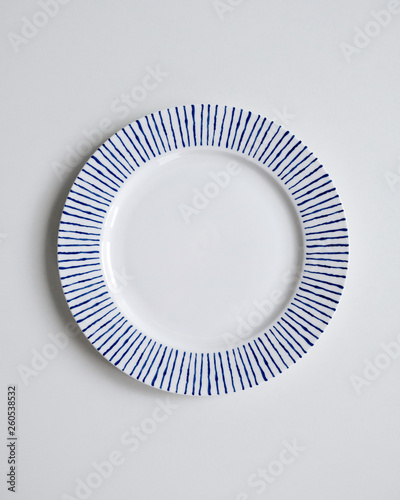 New luxury elegance cutlery view from above on a isolated white background. Top view. Porcelain saucer with blue stripes. Trendy plate. Flat lay view.