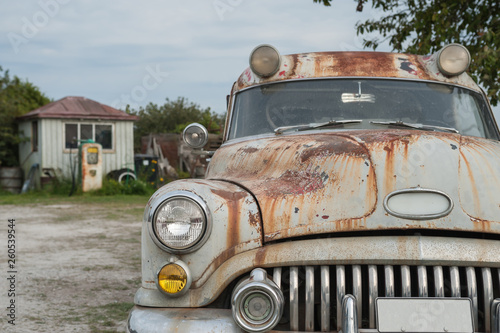 altes, rostiges Auto an einer alten Tankstelle