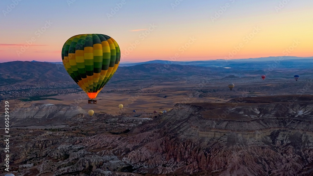 Colorful hot air balloons soaring over the volcanic  valley at sunrise. Cappadocia,Turkey, autumn.