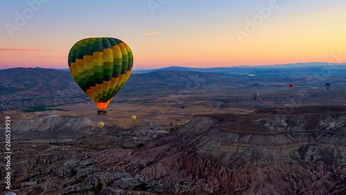 Colorful hot air balloons soaring over the volcanic valley at sunrise. Cappadocia,Turkey, autumn.