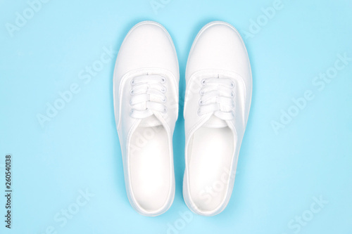 White sneakers on blue background, flat lay..Fashion trend shoe, concept