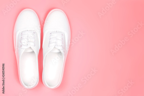 White sneakers on a pink background close-up, copy space.Fashion trend of shoes, shoe shop concept