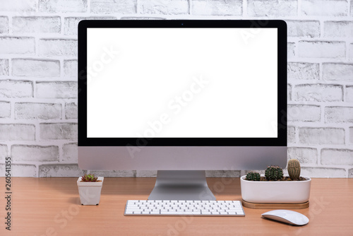 Blank screen of All in one Computer with cactus pots on wooden table, White brick wall background