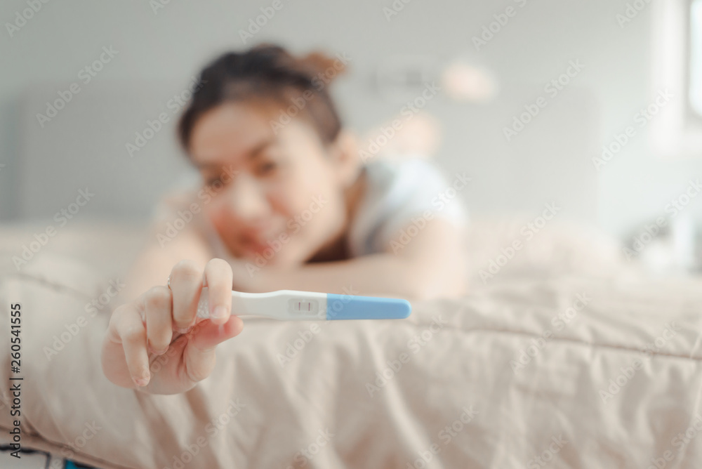 Young asian woman looking at pregnance test in happiness.Pregnancy family concept