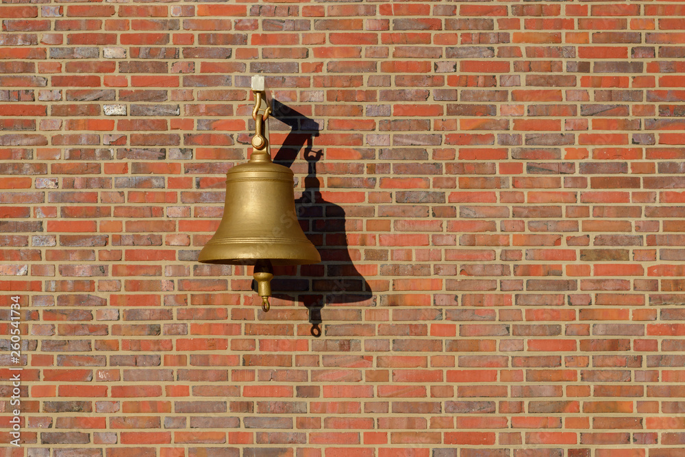 Obraz premium bell hanging on a brick wall
