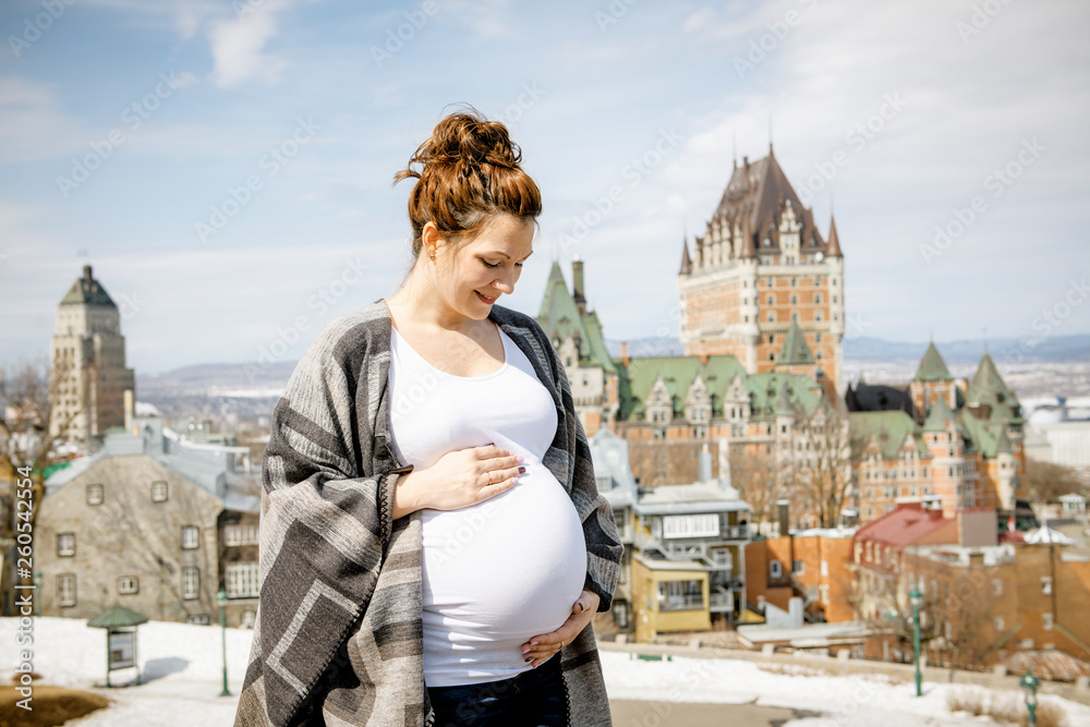 Pregnant girl outside on a city background