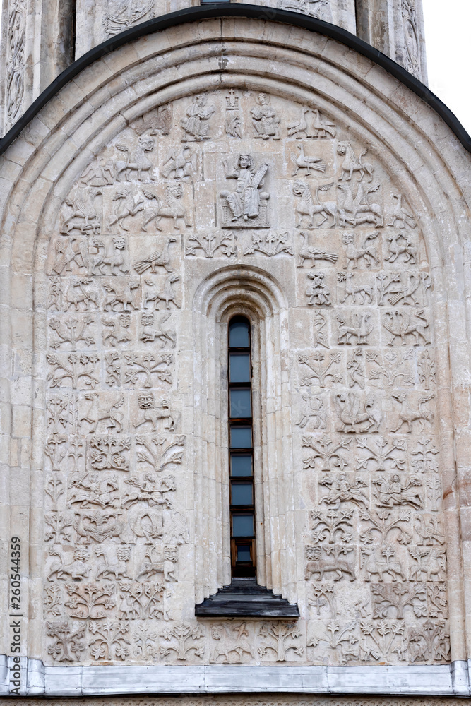 Exterior architectural decorations  St. Demetrius Cathedral, Vladimir, Russia. White stone carving on south wall of the church. sculptural panel framing lancet window. Front view close up