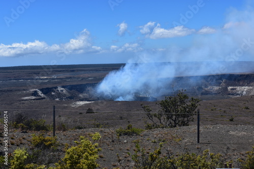 Kilauea Volcano Crater in Hawaii viewed from a distance with smoke rising from the crater
