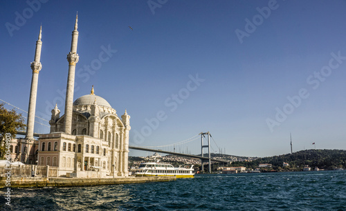 Beautiful view of famous Ortakoy Mosque (Ortakoy Camii) and Bosphorus Bridge (Bogaz Koprusu), Istanbul. Landscape of old Buyuk Mecidiye Mosque under cloudy sky. Islamic house of worship for Muslims.