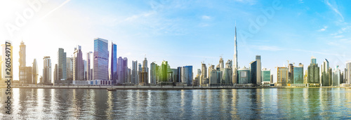 Stunning panoramic view of the Dubai skyline with the magnificent Burj Khalifa and many other buildings, skyscrapers and towers reflected on the Dubai water canal flowing in the foreground. Dubai © Travel Wild