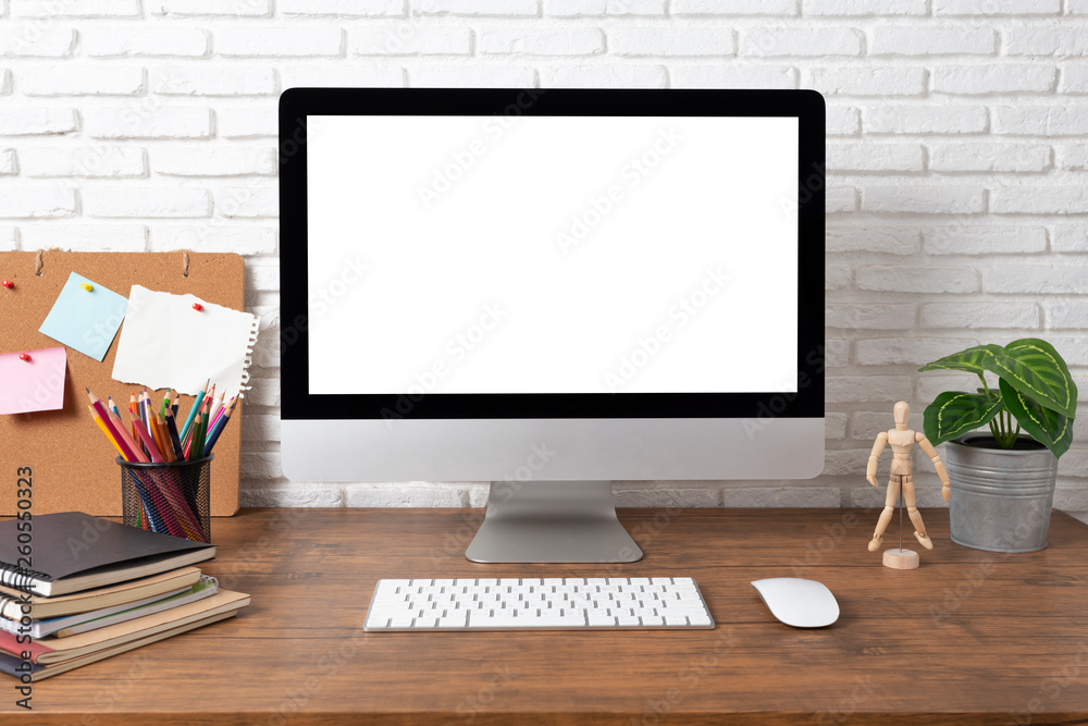 workspace with computer with blank white screen, and office supplies on a wooden desk workspace with computer with blank white screen, and office supplies on a wooden desk