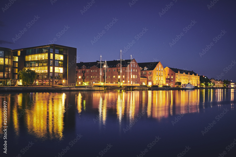 Modern and old buildings on the bank of the canal at night. Copenhagen, Denmark.
