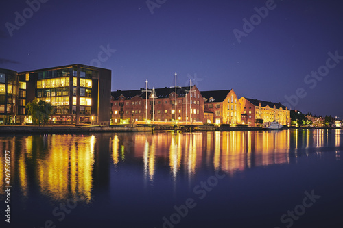 Modern and old buildings on the bank of the canal at night. Copenhagen, Denmark. 