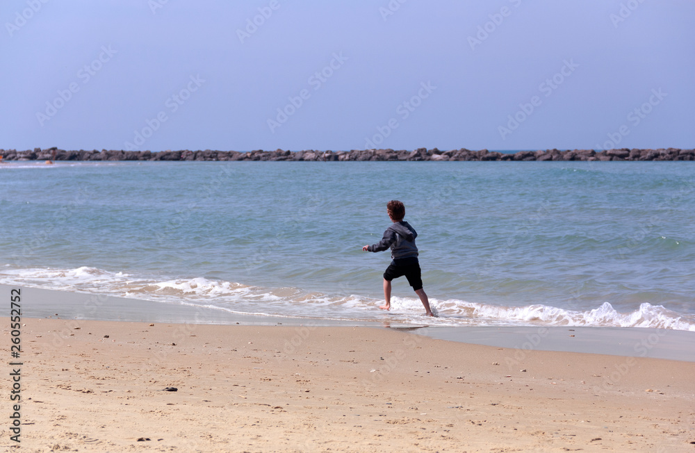child running along the sea as background child running along the sea as background