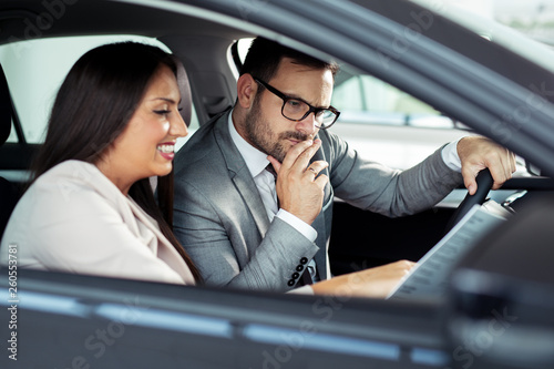 Attractive saleswoman showing inside of a car to customer © zorandim75