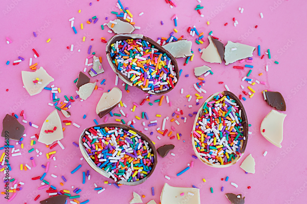 chocolate and pieces of chocolate lie on a bright background, bright candy. white and black chocolate... chocolate and pieces of chocolate lie on a bright background, bright candy. white and black chocolate...