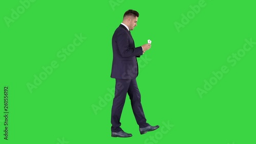 Rich man counts the money walking on a Green Screen, Chroma Key. photo