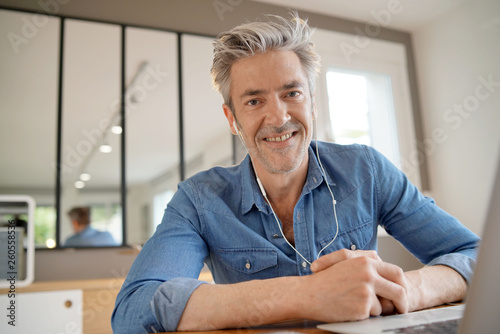 Mature man working from home smiling at camera