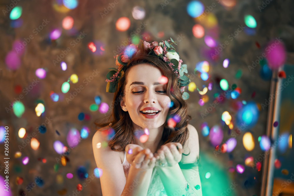 Young beautiful women blowing confetti from hands Young beautiful women blowing confetti from hands