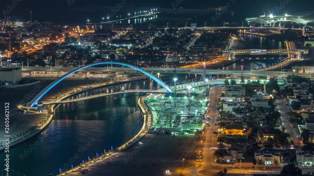 Luxury Dubai Marina canal with passing boats and promenade with palms day to night transition timelapse, Top view from above at evening after sunset. Dubai, United Arab Emirates