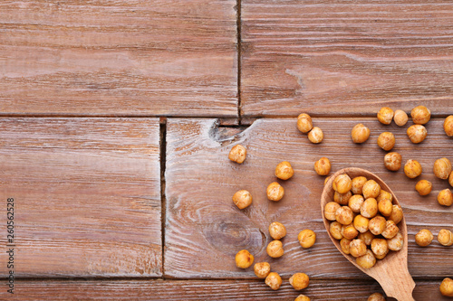 Roasted chickpeas in spoon on brown wooden table